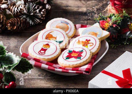 Christmas butter cookies decorated with Christmas graphics, on wooden table. Stock Photo