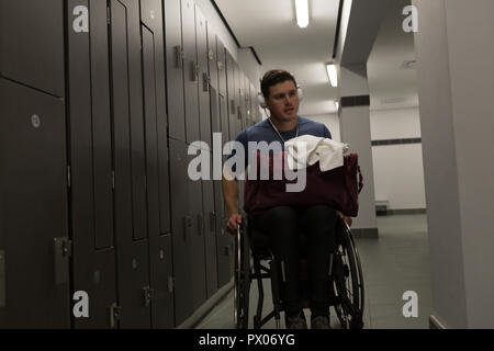 Disabled man with his bag in locker room Stock Photo