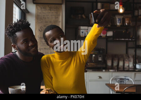 Couple taking selfie in cafe Stock Photo