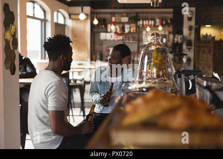 Couple interacting with each other while having beer Stock Photo