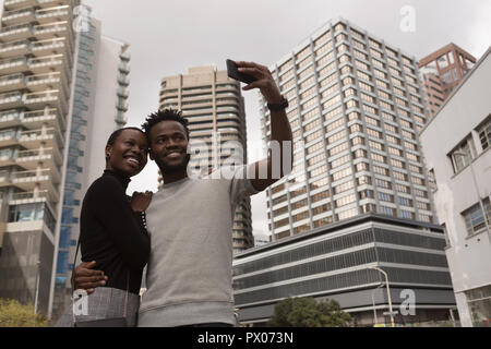Couple taking selfie on city street Stock Photo