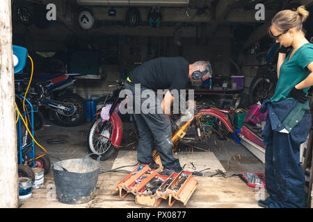 Mechanic using grinder in garage Stock Photo