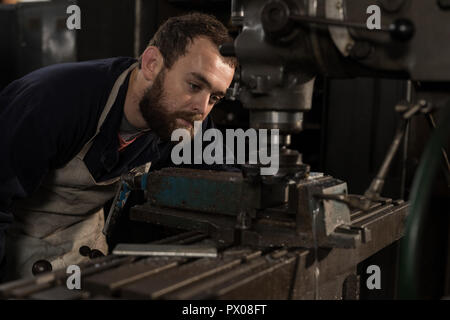 Blacksmith using press drill in workshop Stock Photo