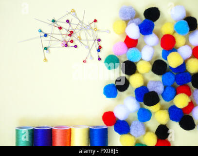 Pins, cotton threads and mini pom-poms, sewing accessories in different vivid color Stock Photo