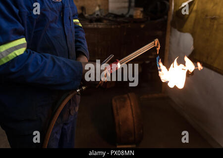 Blacksmith using a welding torch in workshop Stock Photo