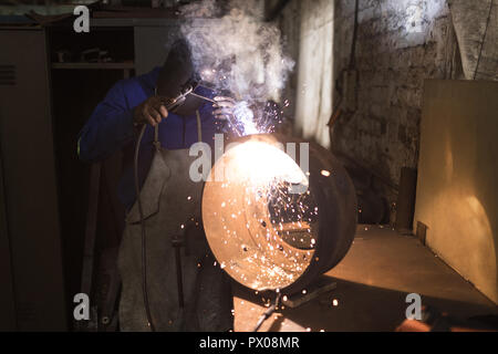 Blacksmith using a welding torch in workshop Stock Photo