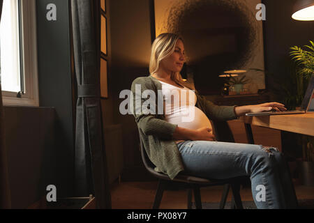 Pregnant woman using laptop Stock Photo