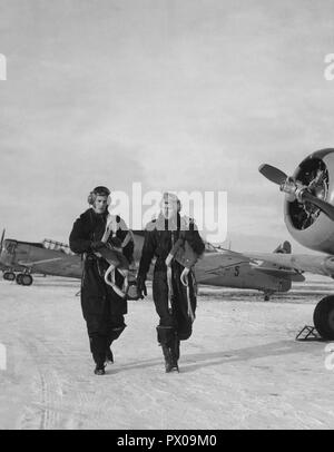 Pilots in the 1950s. Two pilots are walking past  fighter aircraft a winter day. Sweden 1950. Stock Photo