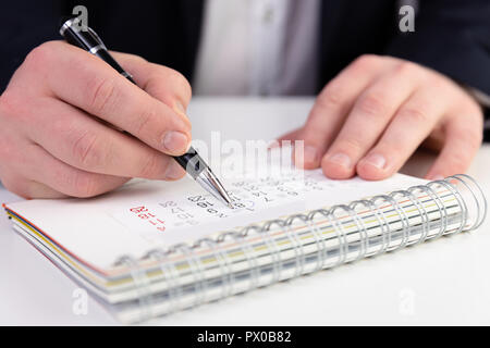 Business man marking a date on a calendar in a dark blue suit. Stock Photo