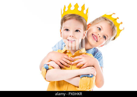 sister hugging brother, kids in yellow paper crowns, isolated on white Stock Photo