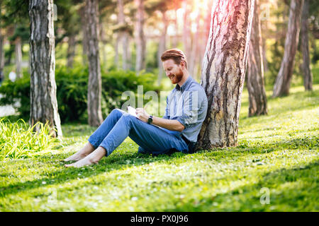 Student studying in park Stock Photo - Alamy