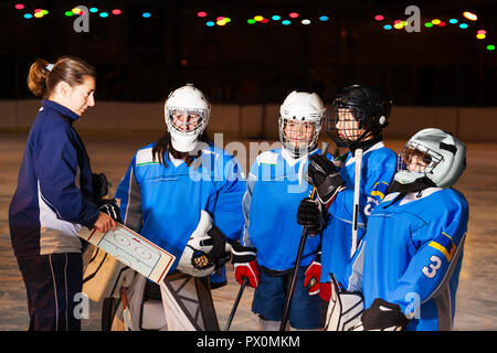 Hockey team listens to coach explaining game plan Stock Photo