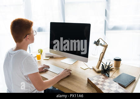preteen ginger hair boy using computer at home Stock Photo