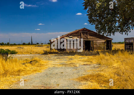 Old Abandoned Wooden Building In Open Field Stock Photo