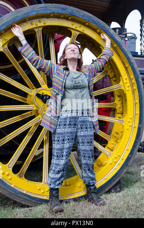 hippy lady in a traction engine wheel Stock Photo