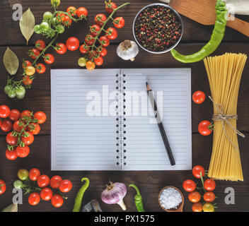 blank notebook with white sheets, raw long paste and ingredients for cooking, top view Stock Photo