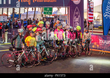 Marathon bicycle escorts take their places at the starting line at the beginning of a marathon at dawn in Huntington Beach, CA. Stock Photo