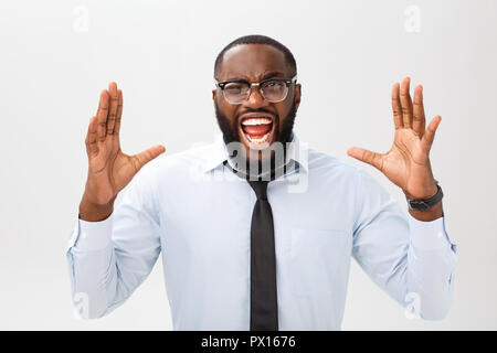 Portrait of desperate annoyed black male screaming in rage and anger tearing his hair out while feeling furious and mad with something. Negative human face expressions, emotions and feelings. Stock Photo