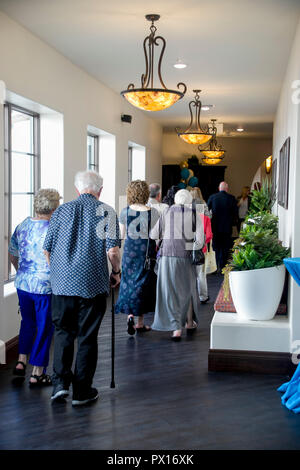 An elderly tour group strolls through a luxury retirement community hallway in Laguna Niguel, CA. Stock Photo