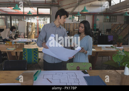 Executives discussing over blueprint Stock Photo