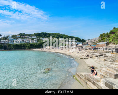 6 June 2018: Looe, Cornwall, UK - Visitors enjoying the beach on a warm and sunny spring day. Stock Photo