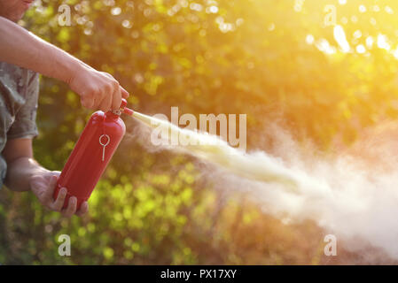 A man demonstrating how to use a fire extinguisher Stock Photo