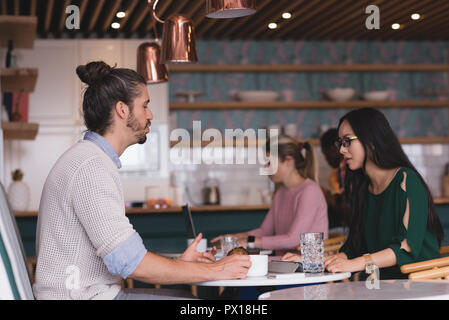 Businessman and businesswoman discussing in the cafeteria Stock Photo