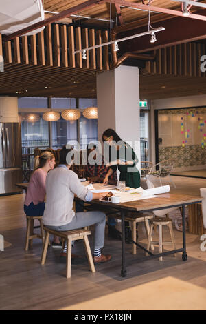 Business people discussing blueprints in the office Stock Photo