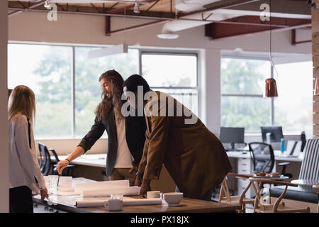 Business people discussing blueprints in the office Stock Photo