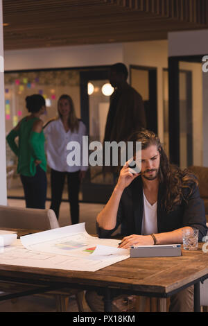 Businessman working on blueprints in the office Stock Photo