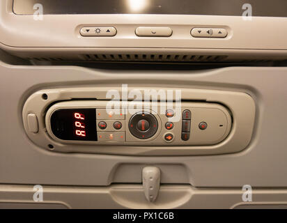 panel with modern remote controller gadget to control airplane airbus multimedia system with keys, joystick, display. close up shot Stock Photo