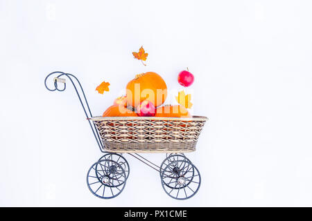 Pumpkins and apples, maple leaves in vintage carriage basket on the white background isolated. Autumn harvest, thanksgiving, halloween concept. health Stock Photo
