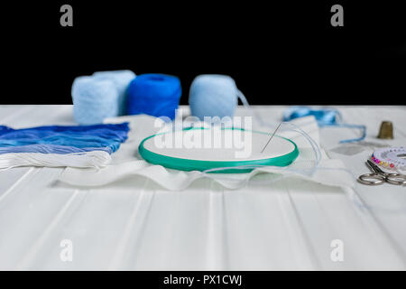 Set for embroidery, embroidery hoop linen fabric, thread, scissors, embroidered needle bed .Top view Stock Photo