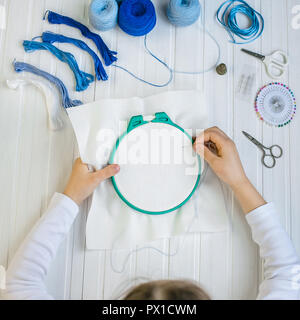 Set for embroidery, embroidery hoop linen fabric, thread, scissors, embroidered needle bed .Top view Stock Photo