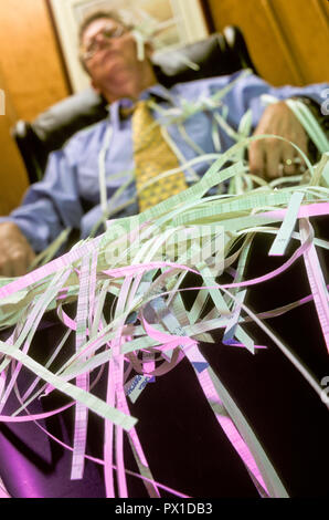 Exhausted Businessman at Paper Shredder, USA Stock Photo