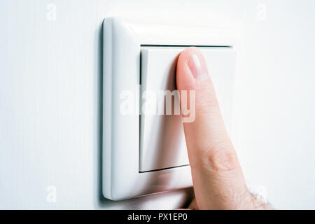 Male Finger Touching A Light Switch To Turn The Light On Or Off Stock Photo