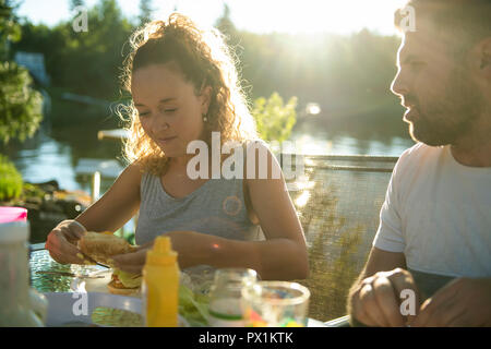 mother eating hamburger outside with his family Stock Photo