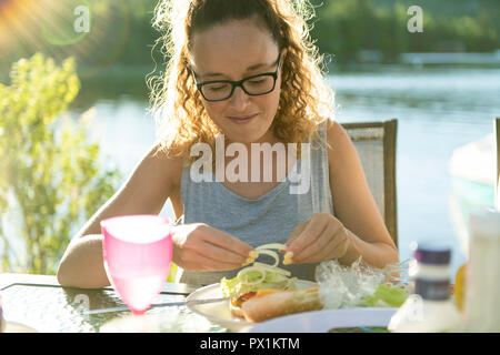 mother eating hamburger outside with his family Stock Photo