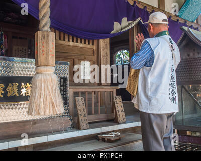 Henro pilgrim praying, and bell rope, Yokomineji temple 60, Shikoku 88 temple  pilgrimage, Ehime, Japan Stock Photo
