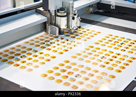 Working digital cutting plotter and yellow smileys Stock Photo