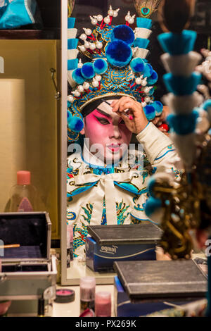 Chinese Opera performer prepares putting on makeup, Ko Shan Theatre, Kowloon, Hong Kong, China. Stock Photo