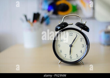 Black alarm clock on the table Stock Photo