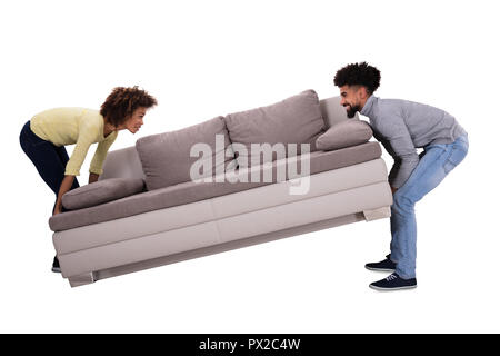 Side View Of An African Couple Carrying Sofa On White Background Stock Photo