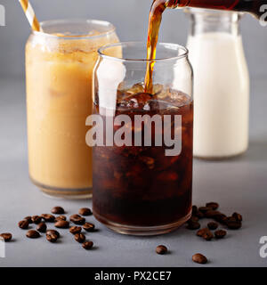 Cold brew iced coffee in glass bottle pouring over Stock Photo