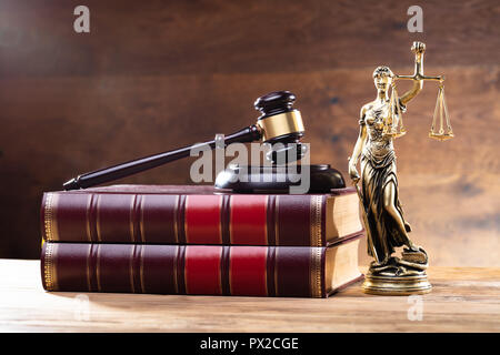 Close-up Of Golden Lady Justice Near Wooden Gavel Over Law Book Stock Photo