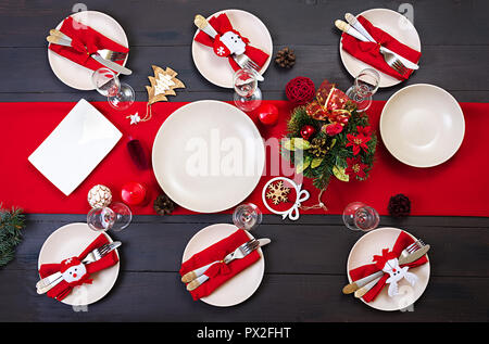 Prepared Christmas table for serving dishes. Scenery, spruce branches, tinsel and candles. Top view Stock Photo