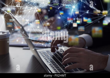 Business man works in office with laptop in the foreground. Concept of teamwork and partnership. double exposure with network effects Stock Photo