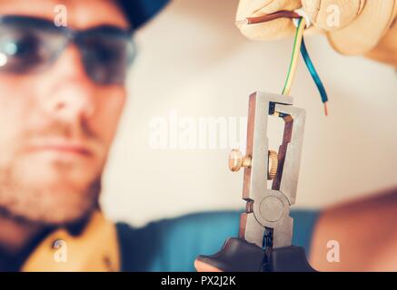 Installing Electrical Point. Caucasian Electrician Preparing Cables. Stock Photo