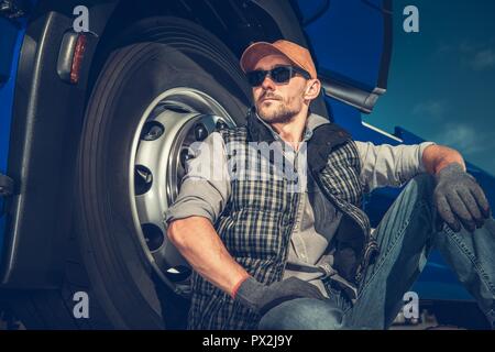 https://l450v.alamy.com/450v/px2j9y/relaxed-caucasian-truck-driver-seating-on-the-ground-and-support-his-back-on-the-semi-truck-wheel-px2j9y.jpg