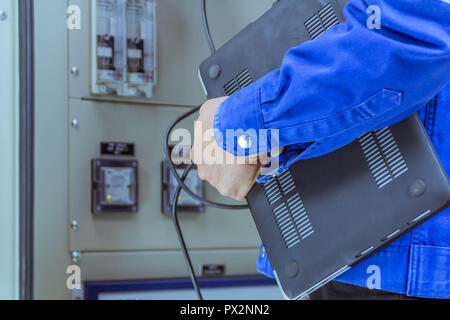 Male engineers are checking the electrical system by program in laptop. Stock Photo